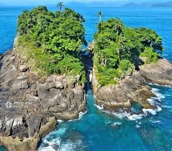 Ilha da Selinha vista de cima, duas ilhotas de mata e rocha em águas azuis